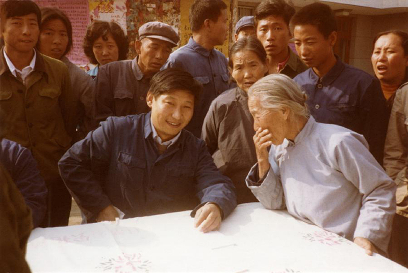 1983年,时任河北正定县委书记的习近平(前排居中),临时在大街上摆桌子听取老百姓意见。