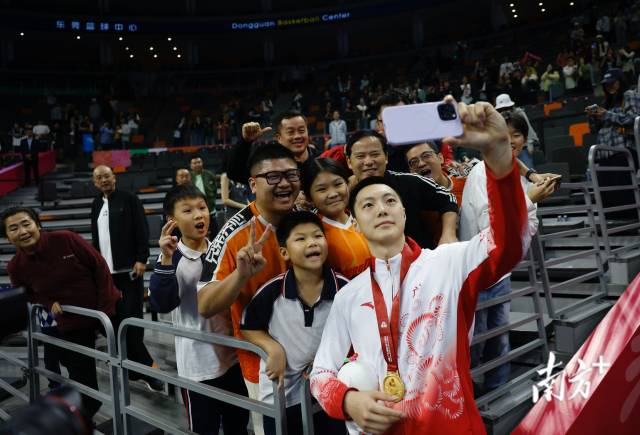 11月12日，十五运会男篮成年组决赛，广东队获得冠军后，胡明轩与球迷们合影留念。张由琼 摄