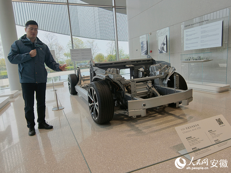 蔚来汽车工作人员介绍车辆底盘及电驱系统。人民网 陶伟摄