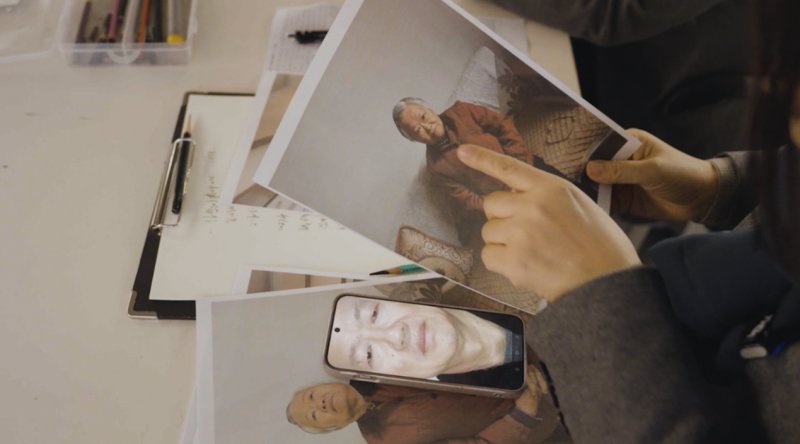 专业老师们探讨烈士亲属容貌特点。人民网记者 邱宇哲摄