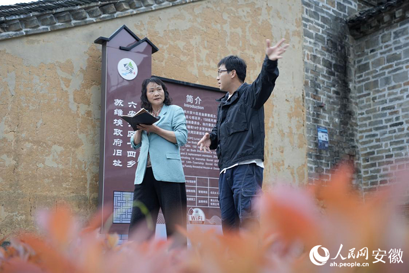 大湾村党总支书记何家枝（左）走访村里的经营户。人民网记者 王锐摄