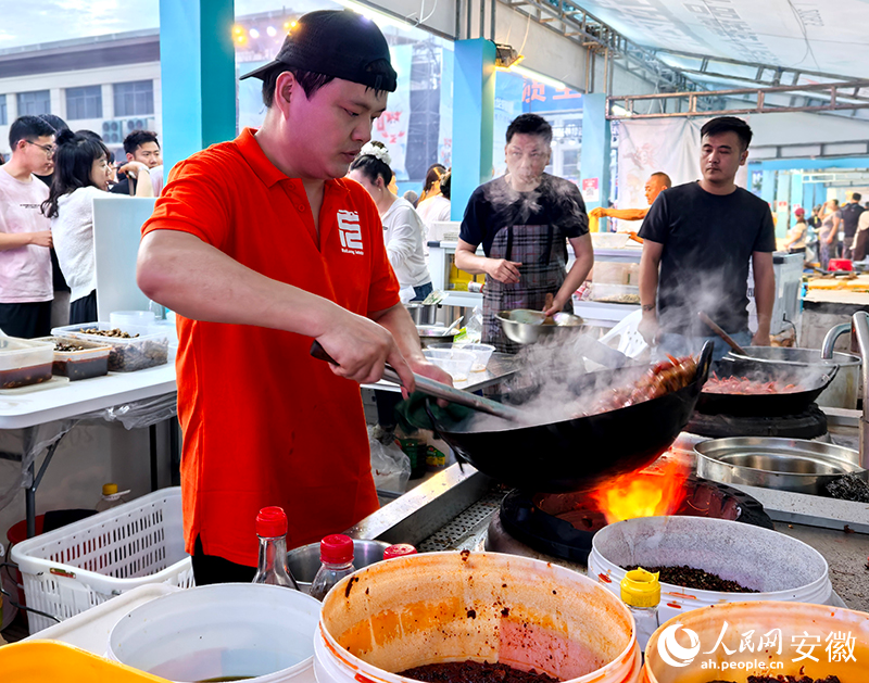 忙着颠锅烹饪小龙虾的龙少武。人民网记者 汪瑞华摄