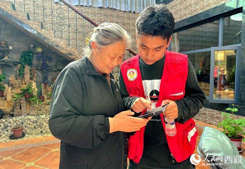 社工丹增释迦帮格桑拉姆老人操作手机。人民网记者 李海霞摄 社工丹增释迦帮格桑拉姆老人操作手机。人民网记者 李海霞摄