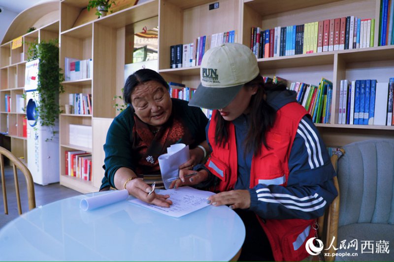 幸福社区的网格员协助老人填写双联户档案表。人民网记者 次仁罗布摄 幸福社区的网格员协助老人填写双联户档案表。人民网记者 次仁罗布摄